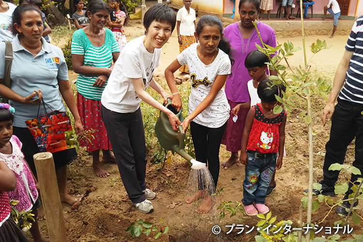 写真：植樹をするチャイルド（中央右）と藤井さん（中央左）