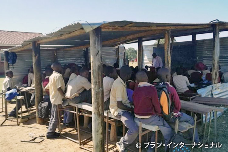 写真：教室が足りず、屋外で授業をする農村部の学校