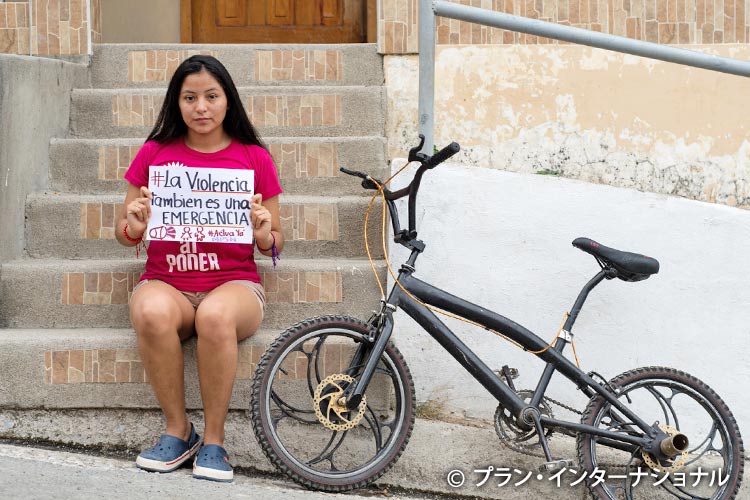 写真：「女の子に対する暴力も緊急事態」とメッセージを掲げる女の（エクアドル）