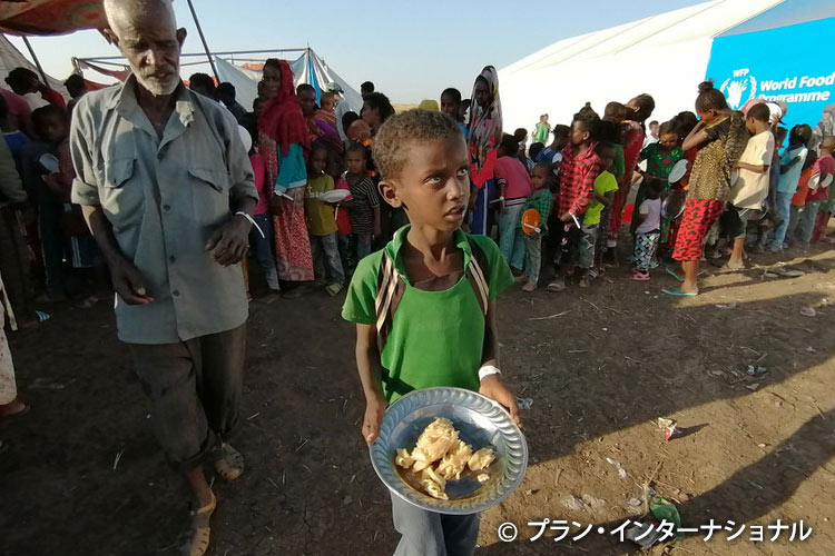 写真：食料を受け取る難民の男の子（スーダン）