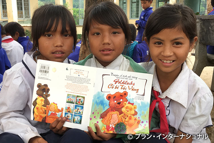 支援で提供された本を読む女の子たち