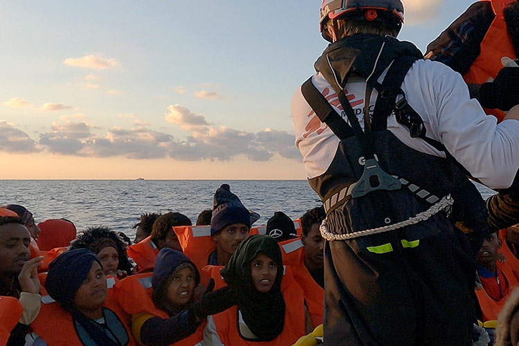 写真：欧州を目指した密航船が漂流し、地中海の洋上で救助される人たち＝2022年1月20日、リビア沖