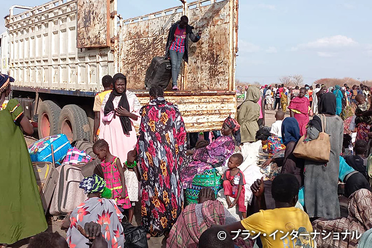 写真：トラックで国外へ避難する難民たち（スーダン）