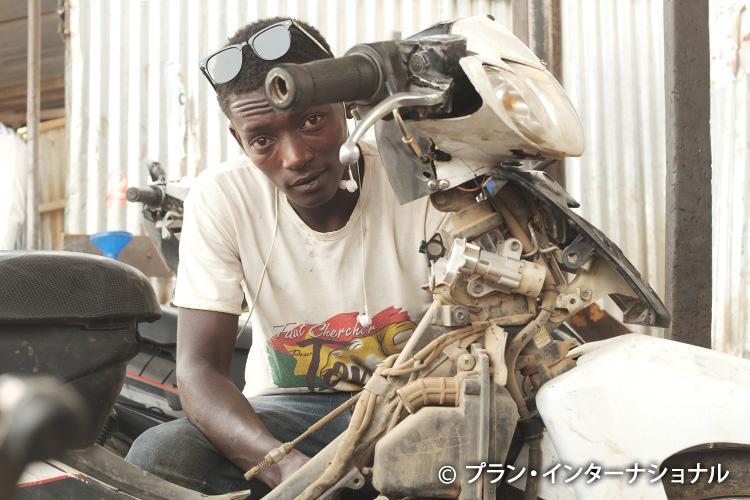 写真：マリから避難した若者。起業トレーニングでバイクの修理技術を身につけた（ブルキナファソ）