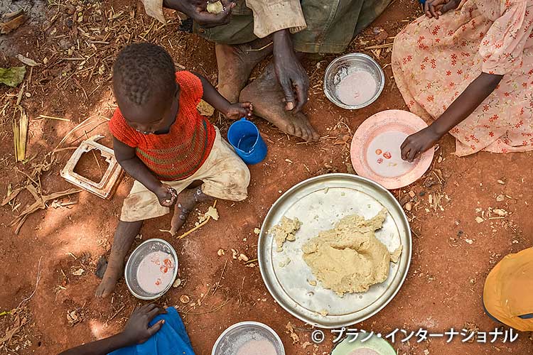 写真：少ない食事を分けあう家族（ウガンダ）