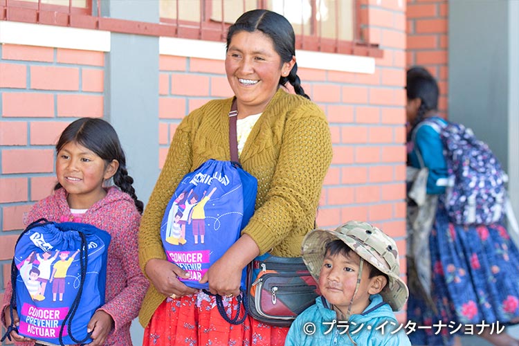 写真：通学に必要な学用品を受け取った親子（ボリビア）