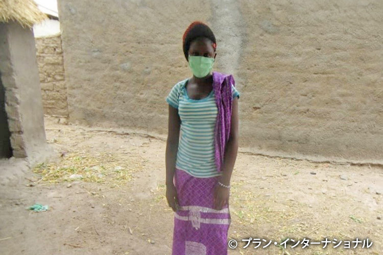 家族に手洗い方法を教えるコミュニティボランティアの女性