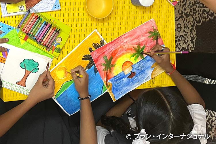 心理社会的ケアの一環のアートセラピーで絵を描く女の子たち（インド）