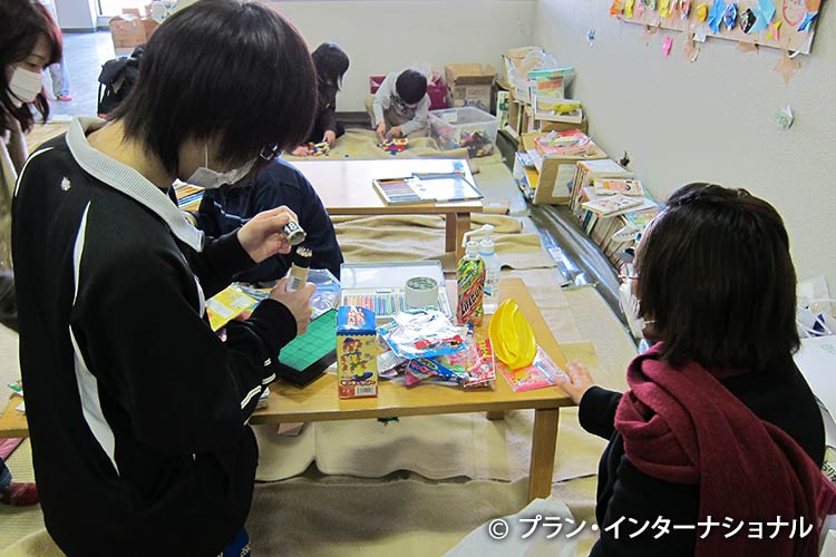 写真：ボランティアが子どもたちを見守る東日本大震災の被災地の子どもひろば（日本）