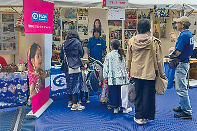 写真：ブースに来た方にパネルで説明