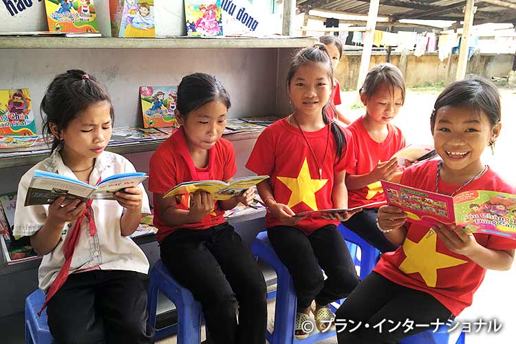 写真：ベトナム語の本を読む少数民族の女の子たち