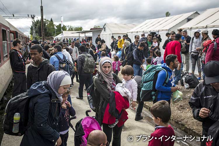 写真：セルビア国境近くの駅に到着したシリア難民