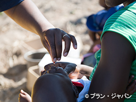 写真：薬を飲む乳幼児（ジンバブエ）