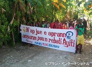 写真：「ハイチ復興のため一緒に遊んで学ぼう」と書かれた横断幕